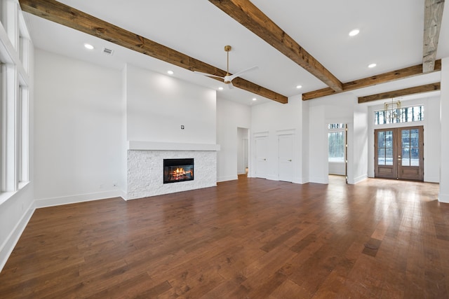 unfurnished living room with dark hardwood / wood-style flooring, french doors, and beamed ceiling