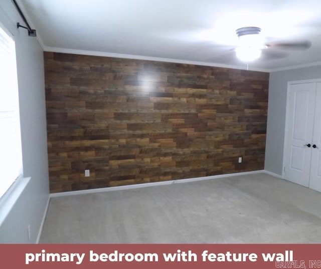 unfurnished room with ornamental molding, wood walls, and ceiling fan