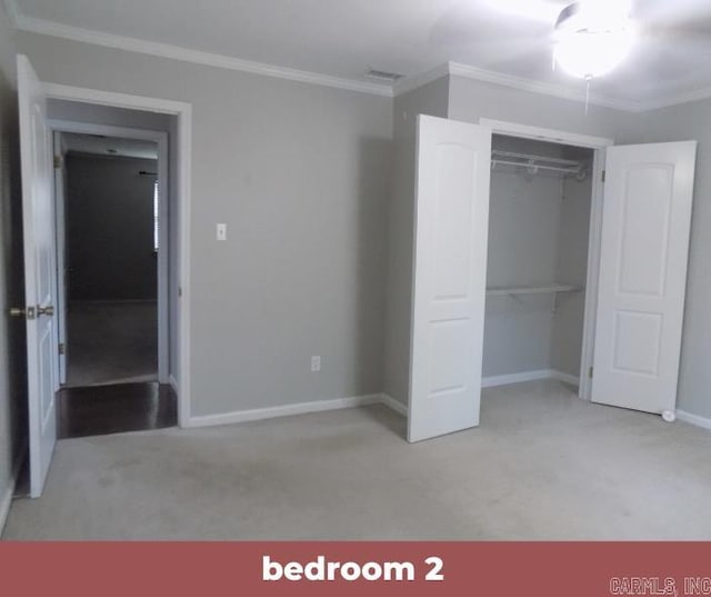 unfurnished bedroom featuring a closet, ornamental molding, and light colored carpet