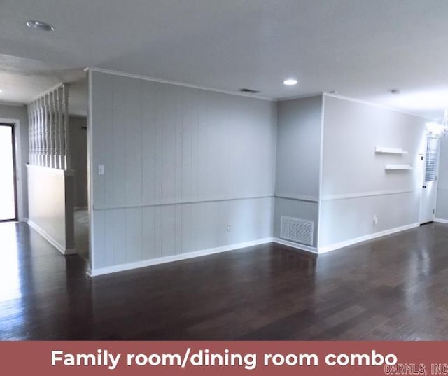 spare room featuring wood walls and dark wood-type flooring