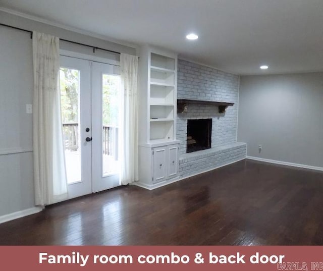 unfurnished living room featuring french doors, a brick fireplace, and dark hardwood / wood-style floors