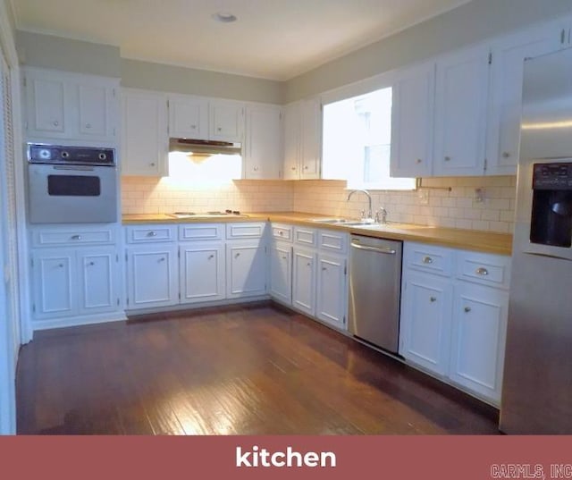 kitchen with white cabinetry, stainless steel appliances, sink, and wood counters