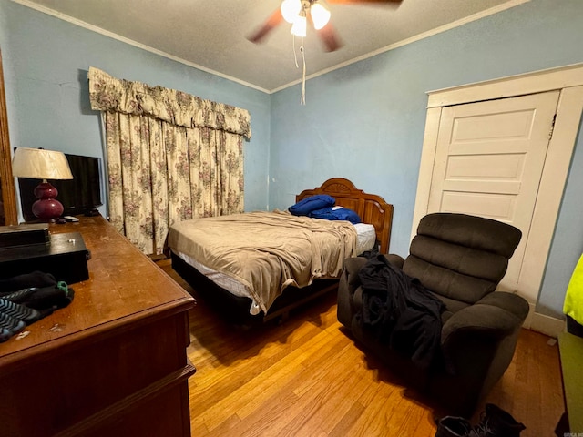 bedroom featuring ornamental molding, light hardwood / wood-style flooring, and ceiling fan