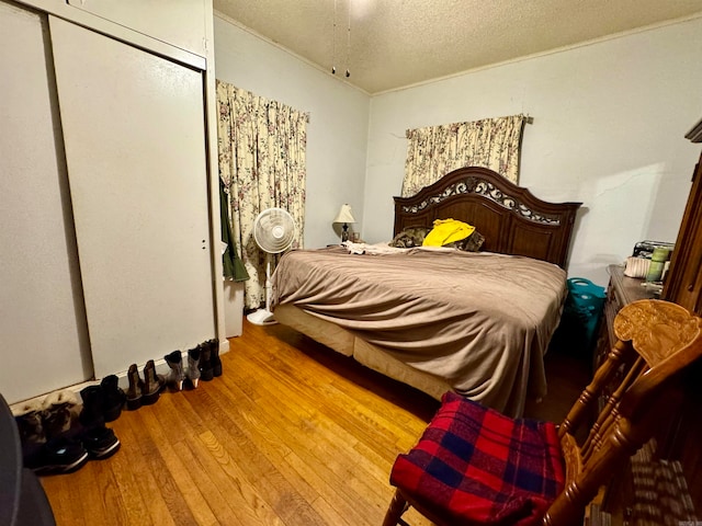 bedroom with a textured ceiling and wood-type flooring