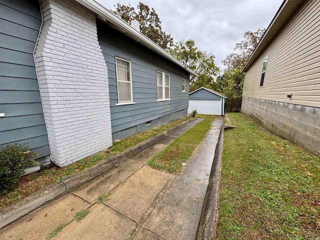 view of property exterior featuring a yard, an outbuilding, and a garage