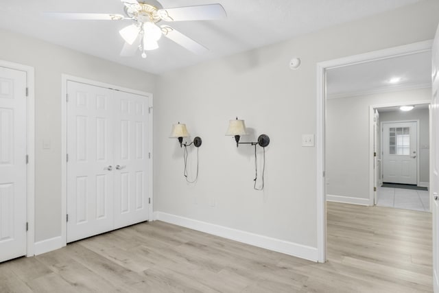 interior space with crown molding, ceiling fan, and light hardwood / wood-style flooring