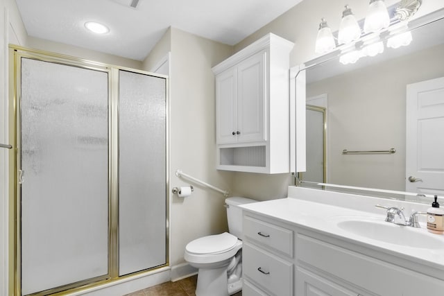 bathroom with vanity, toilet, tile patterned floors, and a shower with shower door