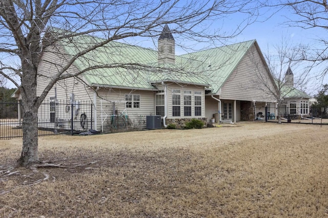 rear view of property featuring a yard and central air condition unit