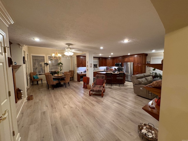 living room featuring a notable chandelier, a textured ceiling, and light wood-type flooring