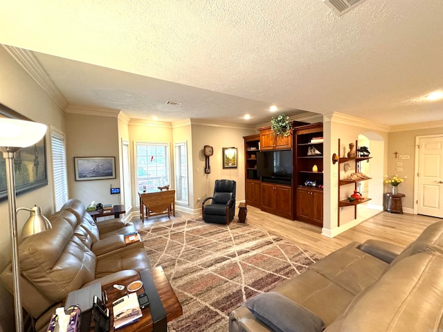 living room with crown molding, hardwood / wood-style floors, and a textured ceiling