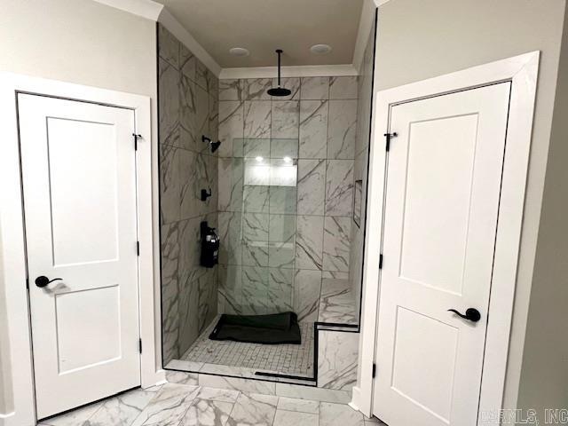 bathroom featuring crown molding and a tile shower