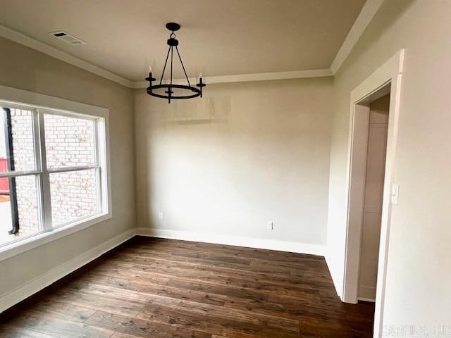 unfurnished dining area with ornamental molding, an inviting chandelier, and dark hardwood / wood-style floors