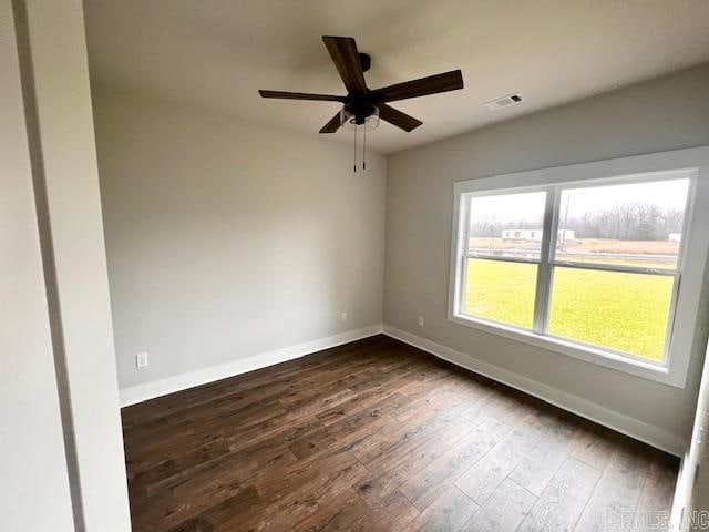 empty room featuring dark wood-type flooring and ceiling fan