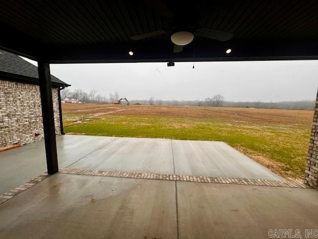 view of patio / terrace with ceiling fan and a rural view