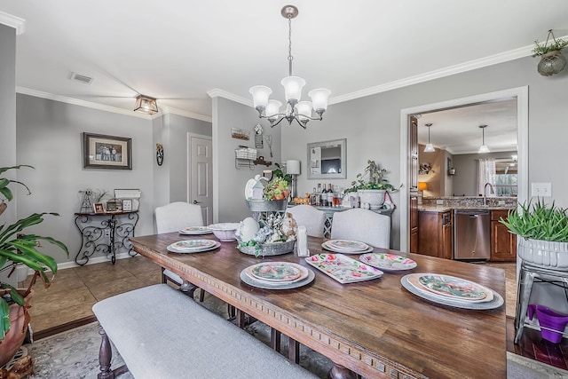 dining area featuring sink, crown molding, light tile patterned floors, and a chandelier