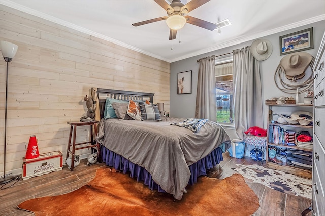 bedroom featuring ornamental molding, wood walls, dark wood-type flooring, and ceiling fan