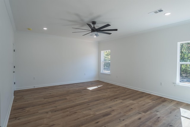 spare room featuring ornamental molding, ceiling fan, dark hardwood / wood-style floors, and plenty of natural light