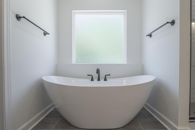 bathroom with a tub and tile patterned floors