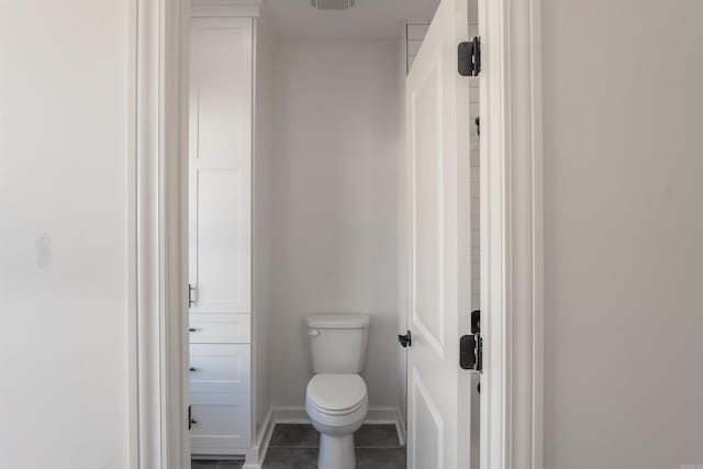 bathroom featuring toilet and tile patterned flooring