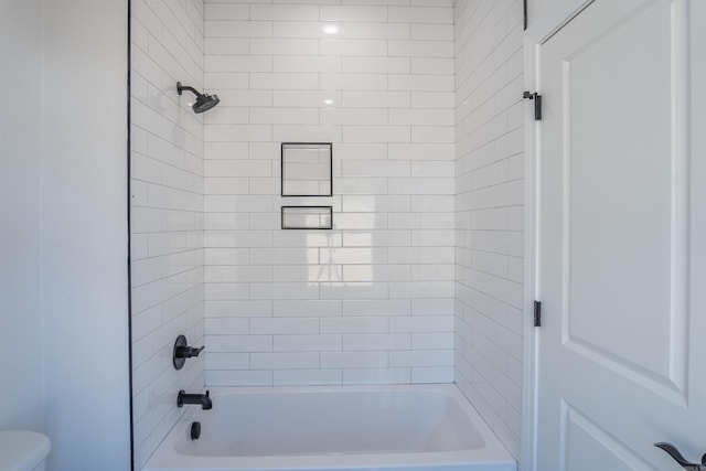 bathroom with toilet and tiled shower / bath combo