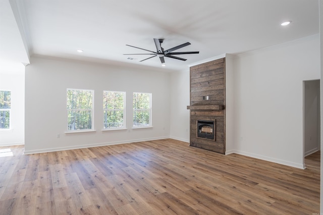 unfurnished living room with ornamental molding, light wood-type flooring, and a wealth of natural light