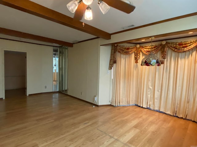 spare room with beamed ceiling, crown molding, wood-type flooring, and ceiling fan