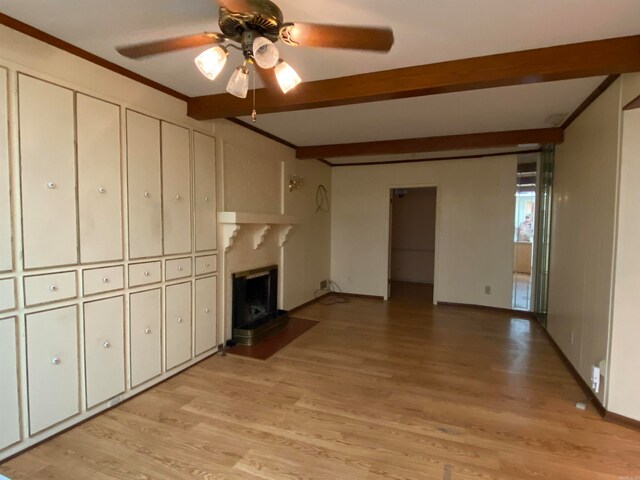 unfurnished living room featuring light hardwood / wood-style flooring, ceiling fan, beamed ceiling, and crown molding