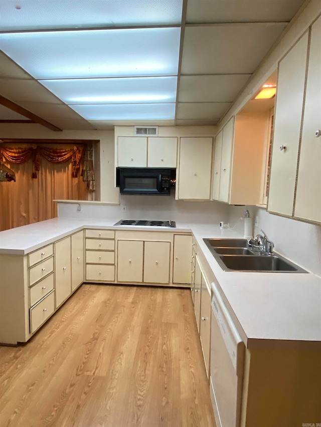 kitchen with white appliances, light hardwood / wood-style flooring, cream cabinets, and sink