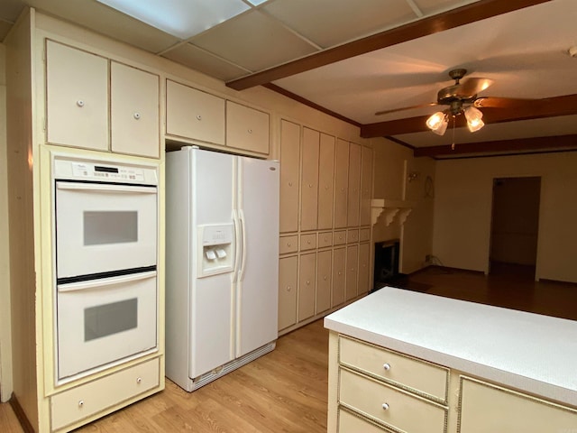 kitchen with light hardwood / wood-style floors, cream cabinets, white appliances, and ceiling fan