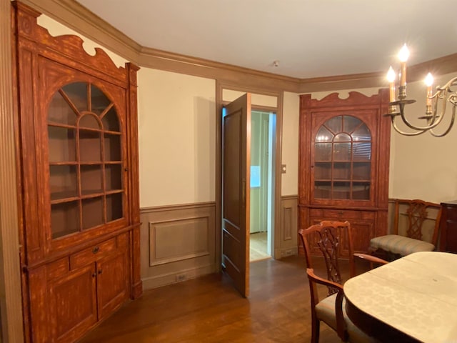 dining room with dark wood-type flooring, crown molding, and an inviting chandelier