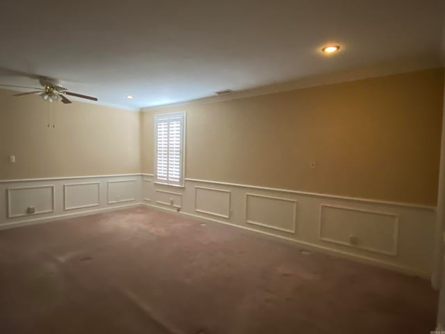 spare room featuring ornamental molding, carpet flooring, and ceiling fan