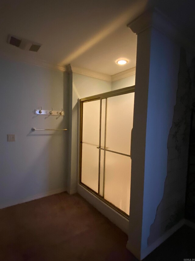 bathroom with a shower with door and ornamental molding