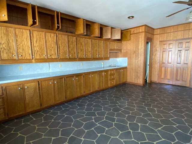 kitchen with dark tile patterned flooring, ceiling fan, and sink