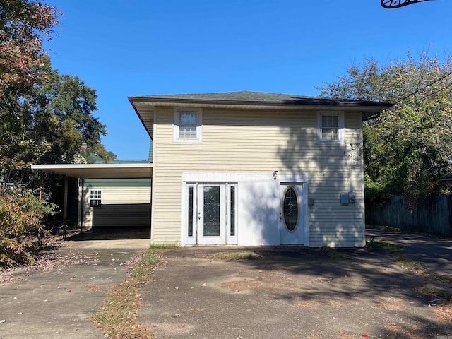 back of house featuring a carport