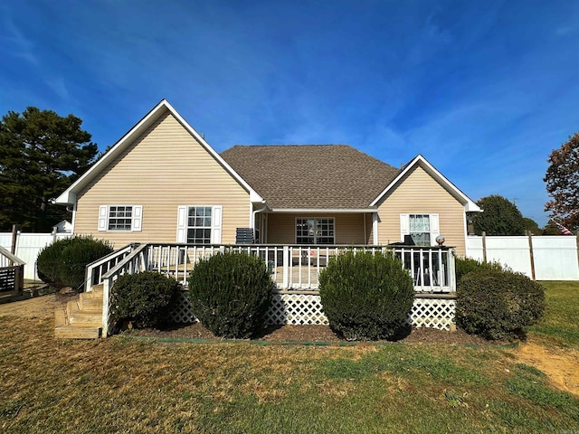 back of property with a deck and a lawn