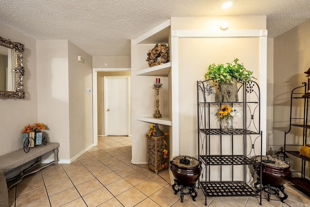 corridor with a textured ceiling and light tile patterned floors