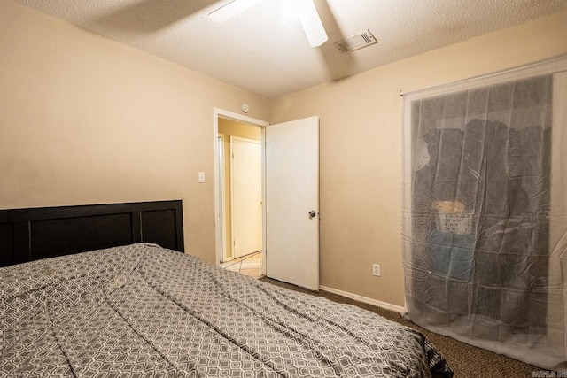 bedroom with carpet floors, a textured ceiling, and ceiling fan