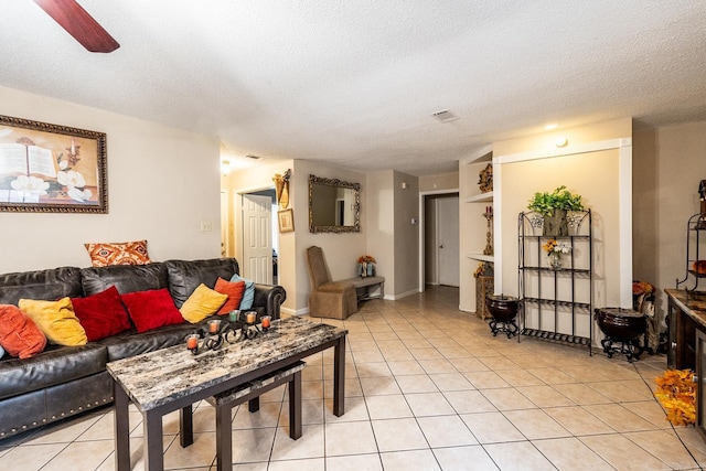 tiled living room featuring ceiling fan and a textured ceiling