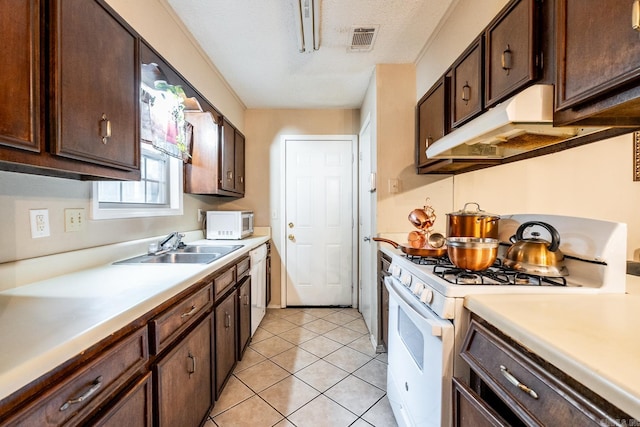 kitchen with white appliances, dark brown cabinets, light tile patterned floors, and sink