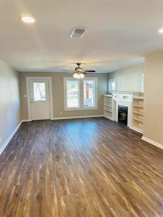 unfurnished living room with ceiling fan, dark hardwood / wood-style flooring, and a fireplace