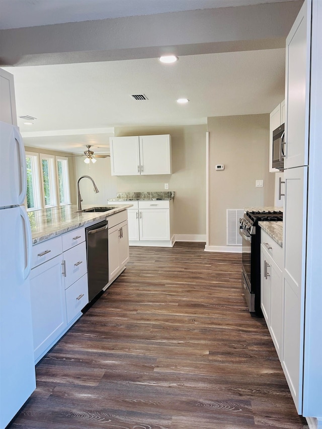 kitchen with sink, appliances with stainless steel finishes, dark hardwood / wood-style floors, and white cabinets