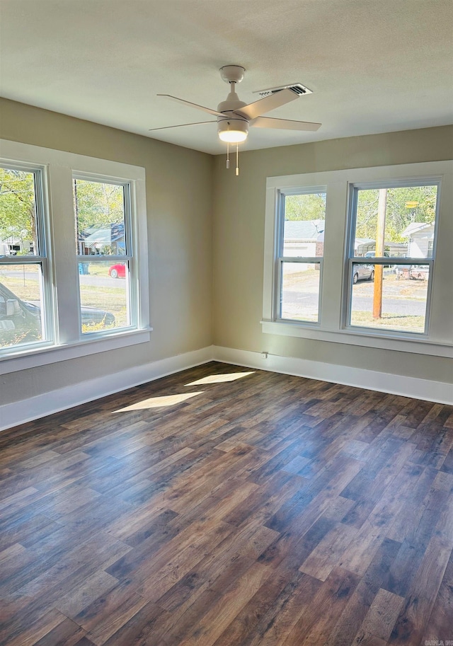 unfurnished room featuring dark wood-type flooring and ceiling fan