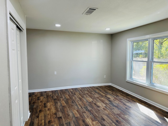 unfurnished bedroom featuring a closet and dark hardwood / wood-style floors