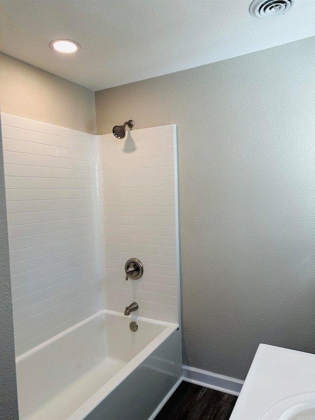 bathroom featuring vanity, hardwood / wood-style flooring, and tiled shower / bath