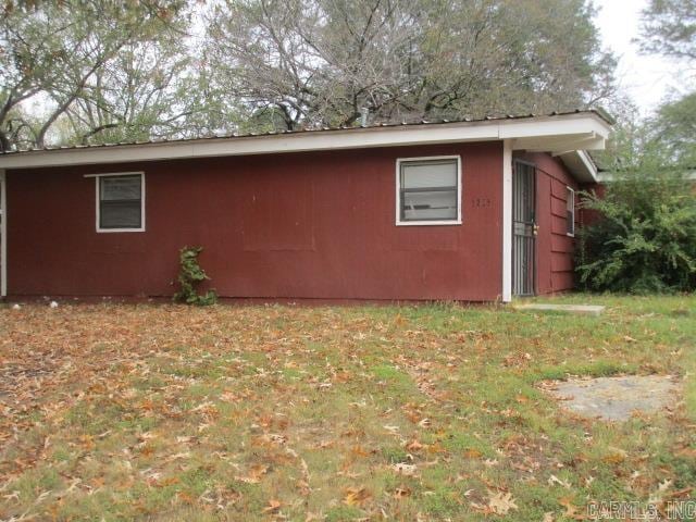 view of side of home with a yard