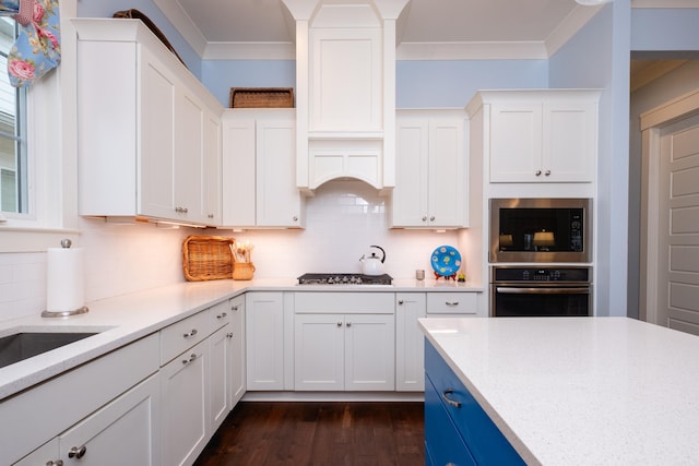 kitchen featuring crown molding, white cabinets, stainless steel appliances, and dark wood-type flooring