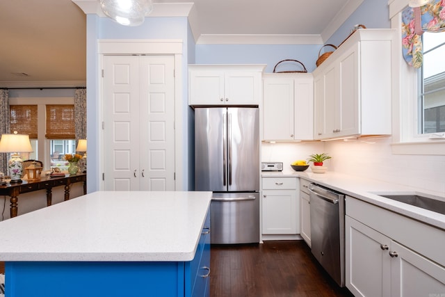 kitchen featuring a kitchen island, dark hardwood / wood-style floors, stainless steel appliances, crown molding, and white cabinetry