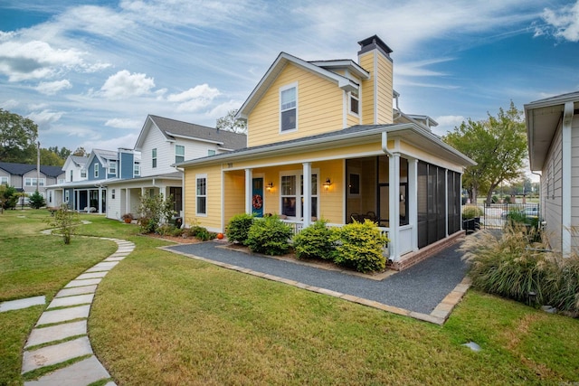 view of front facade with a front lawn and a sunroom