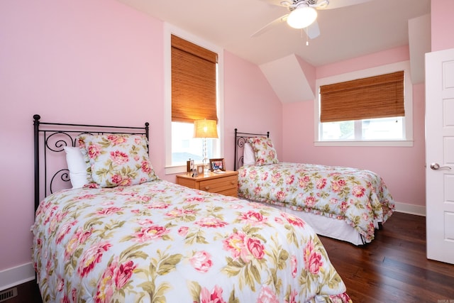 bedroom featuring multiple windows, dark wood-type flooring, and ceiling fan