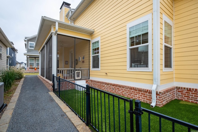 view of side of home featuring a lawn and a sunroom